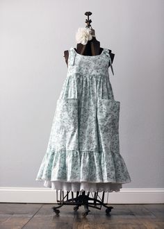 a dress on a mannequin in front of a white wall and wooden floor