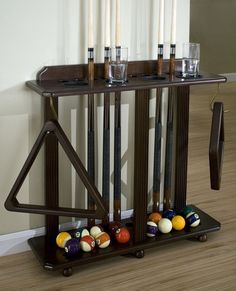 a rack with pool balls and cues in it