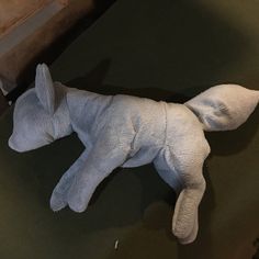 a white stuffed animal laying on top of a table