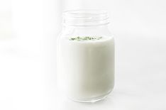 a glass jar filled with milk sitting on top of a table