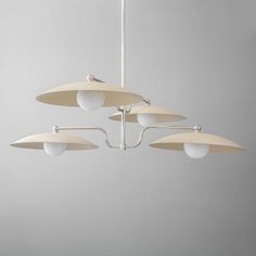 four light chandelier hanging from the ceiling in a room with gray walls and flooring