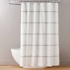 a white shower curtain hanging on a metal rod