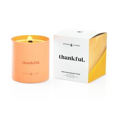 an orange candle sitting next to a box on a white surface with the words, thank fut