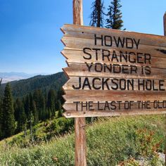 a wooden sign that is on the side of a hill