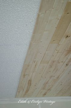 wood planks on the ceiling in a room with white walls and trim around it