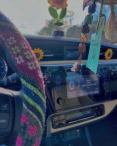 the inside of a car with sunflowers and flowers hanging from it's dashboard