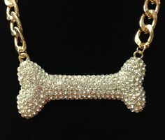 a gold chain with a dog bone on it