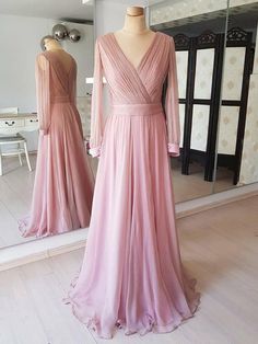 a pink dress is on display in front of a mirror and mannequins