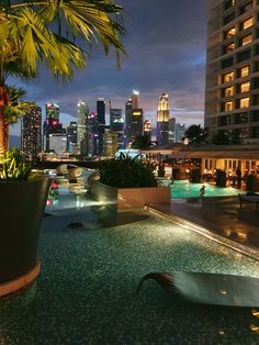 an outdoor swimming pool with city lights in the background