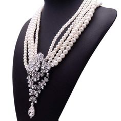 This amazing statement piece will turn heads and garner TONS of compliments when you wear it! Multiple strands of varied sized pearls join together in one amazing necklace flanked by an absolutely STUNNING array of white gems clustered into a blaze of bling at the bottom! Includes free earrings. Lead and Nickel Free. #AffordableJewelry #Amazing #Beautiful #FauxPearl #Beauty #Bling_Bling #Blingtastic #BridalJewels #DiscoverFashion #EnvyWear #FashionGoals #JewelryAddict #PursuePretty #StatementNec Glamorous White Pearl Chain Necklace, Party Pearl Necklace With Crystal Pendant, White Pearl Chain Bridal Necklace, Glamorous White Pearl Necklace, Glamorous White Pearl Embellished Necklace, Glamorous White Beaded Pearl Necklace, Pearl White Crystal Pearl Chain Necklace, Bridal Jewels, Diamonds And Pearls