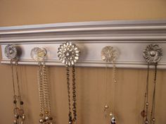 a bunch of necklaces are hanging on the wall