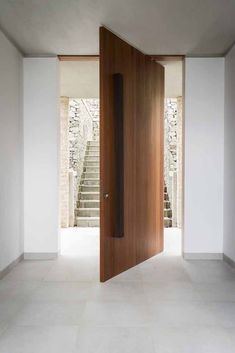 an open door in a white room with stairs