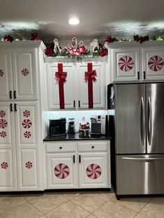 a kitchen decorated for christmas with white cabinets and candy canes on the counter top