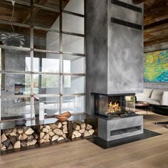 a living room filled with furniture and a fire place in the middle of a wooden floor