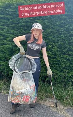 a woman with pink hair is holding a garbage bag and wearing a black t - shirt that says garbage rat would be so proud of my littering haul today