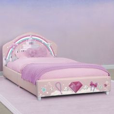 a child's bed with a pink headboard and foot board on the floor