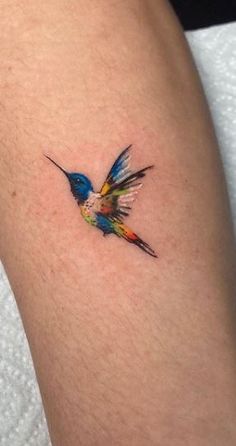 a small colorful bird tattoo on the leg