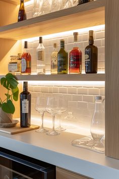 bottles and glasses are lined up on the shelves