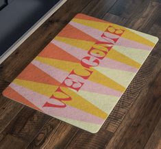 a bathroom rug with the word vacava written in bold red, yellow and pink stripes