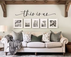 this is us wall decal above a couch in a living room with pictures on the wall