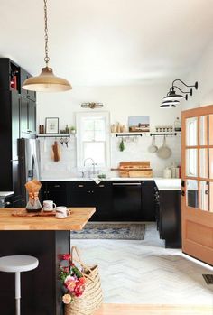 the kitchen cabinets are black and white with wood trimmings on the countertop