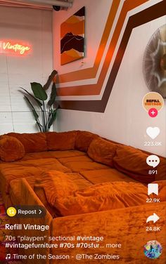 an orange couch sitting in front of a white wall