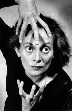 an old black and white photo of a woman holding her hands up to her face