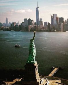 the statue of liberty overlooks the city skyline