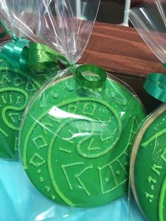 three green cookies wrapped in plastic on top of a table