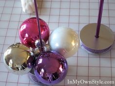 several ornaments are on the table with purple and white balls