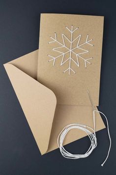 a card with a snowflake cut out of it next to a pair of scissors