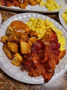 two white plates filled with breakfast foods on top of a table next to each other