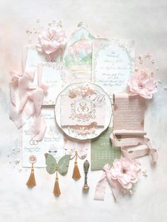 the wedding stationery is laid out on top of each other, with pink flowers