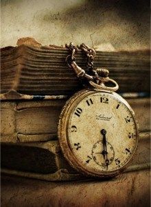 an old pocket watch sitting on top of books