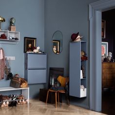 a living room with blue walls and shelves filled with various items on top of them