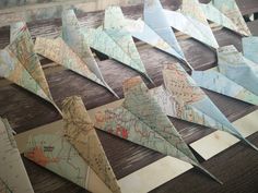 several origami airplanes sitting on top of a wooden table next to each other