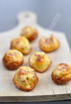 small pastries sitting on top of a wooden cutting board