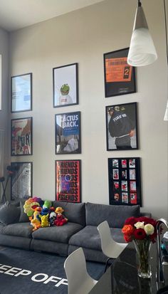 a living room filled with furniture and pictures on the wall