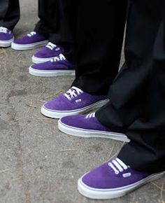 several people wearing purple shoes standing in a row