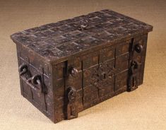 an old wooden box sitting on top of a table next to a brown carpeted floor