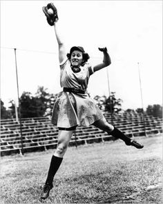 an old black and white photo of a woman in the air catching a baseball with her glove