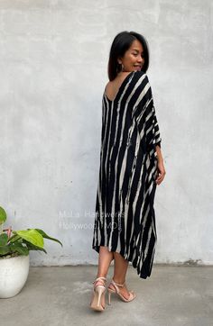 This kaftan complements all body types with its long, loose design and slits up both sides. The unique pattern is created by using a discharge dye process to remove color. I use a high quality rayon voile fabric that both flows and drapes around you. The eco printed kaftan can be worn in many stylish ways to make you look your best. DETAIL * All measurements are flat * Bust/ Waist/ Hips 34 in (Circumference 68 in.) * Arms 11 in. (Circumference 22 in.) * Length 42 in. * V-Neck * Side slits * No p Loose Fit Tunic Midi Dress For Beach, Oversized Tunic Midi Dress For Beach, Oversized V-neck Midi Dress For Beach, Oversized Black Tunic For Beach, Oversized Black Tunic For The Beach, Printed Tunic Midi Dress For The Beach, Beach Tunic Midi Dress With Print, Black Beach Maxi Dress With Kimono Sleeves, Black Beach Dress With Batwing Sleeves