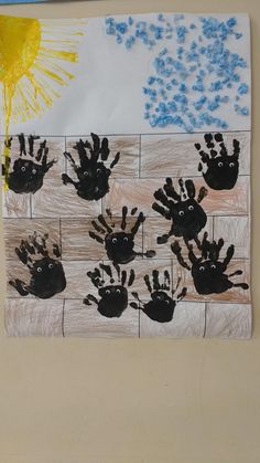 handprints on a piece of paper with blue flowers and sun in the background