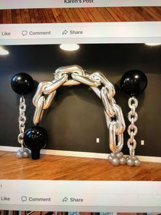 a large metal chain hanging from the side of a wall with balloons attached to it