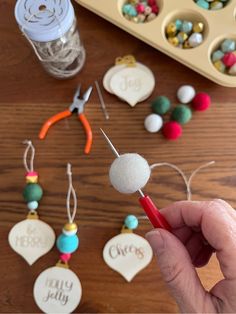 a person holding a red pen in front of some crafting supplies on a table