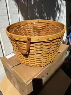 a wicker basket sitting on top of a cardboard box