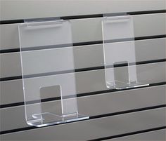 two clear acrylic displays on a wall with black and white striped walls behind them