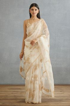 Ivory saree with all over blooming flowers hand embroidery in dori and hand adda work.
Components: 1
Pattern: Hand Embroidery
Type Of Work: Dori, Adda, Floral
Fabric: Silk Organza, Cotton Silk
Color: Ivory
Other Details: 
Scallop trimmed saree
Note: The stitched blouse worn by the model is not for sale
Occasion: Wedding - Aza Fashions Off White Silk Saree, Ivory Saree, White Sarees, Raw Silk Embroidery, Dori Embroidery, Women Saree, White Saree, Saree For Women, Indian Dresses Traditional