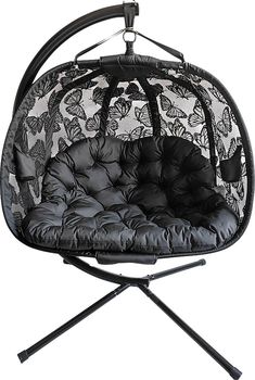 a black and white photo of a hanging chair with butterfly print on the fabric,