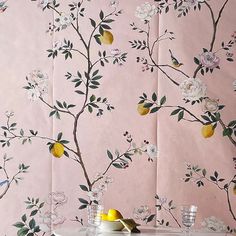 the wallpaper has lemons and flowers on it, as well as two glasses